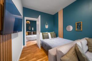 1 dormitorio con paredes azules, 1 cama y 1 sofá en Cavallo Business Apartments, en Praga