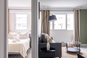 a bedroom with a bed and a chair and a table at Appartement Charmant à Levallois in Levallois-Perret