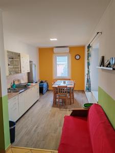 a kitchen with a red couch and a table at Glázer Szállás in Tapolca