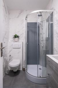 a white bathroom with a shower and a toilet at Appartement Charmant à Levallois in Levallois-Perret