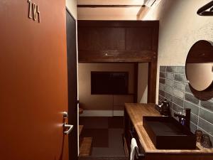 ein Bad mit einem Waschbecken und einem Spiegel in der Unterkunft RoheN HakoneYumoto in Hakone