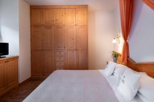 a bedroom with a large bed and a tv at Hotel Castel Pietra in Fiera di Primiero
