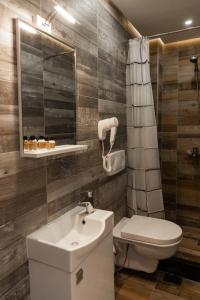 bagno con lavandino, servizi igienici e specchio di Hotel City Star a Pristina