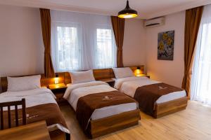 a bedroom with two beds and a couch at Hotel City Star in Prishtinë