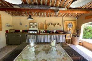 uma cozinha com uma mesa de vidro num quarto em Comfortable house with large garden and jacuzzi em Rognes