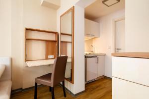 eine kleine Küche mit einem Stuhl und einem Spiegel in der Unterkunft Helgolandia Apartments in Helgoland