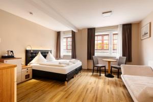 ein Hotelzimmer mit einem Bett, einem Tisch und Stühlen in der Unterkunft Helgolandia Apartments in Helgoland