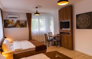 a bedroom with a bed and a table and a television at Hotel City Star in Pristina