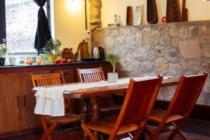 a dining room table with chairs and a stone wall at Vía Láctea in Tilcara
