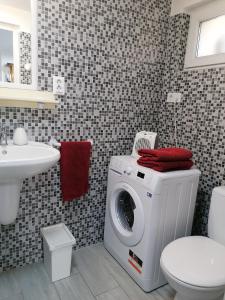 a bathroom with a washing machine and a sink at A nyugalom szigete Tabán Apartman in Dunakeszi