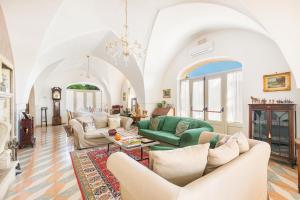 sala de estar con muebles y lámpara de araña. en Casino Casalino by Perle di Puglia, en Francavilla Fontana