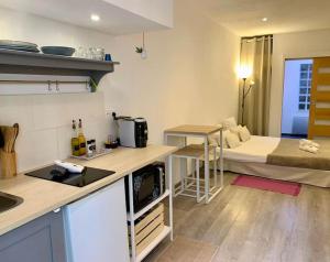 a small kitchen with a bed in a room at "Pascal 1" Eglise St Louis - Studio Cosy Quartier Haut in Sète