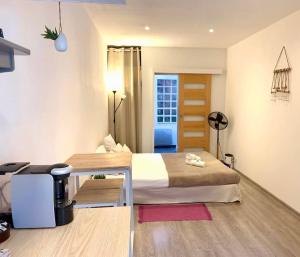 a bedroom with a bed and a desk in a room at "Pascal 1" Eglise St Louis - Studio Cosy Quartier Haut in Sète