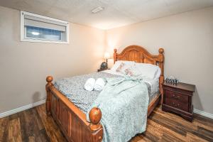 a bedroom with a wooden bed with two towels on it at A-Home by chinook mall and Heritage park in Calgary
