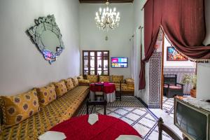 uma sala de estar com um sofá e uma mesa em Riad Jamal em Fez