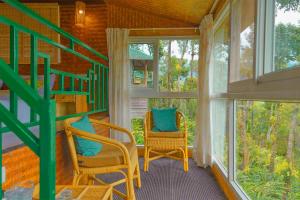 een kamer met 2 stoelen en een trap in een huis bij Sitaram Mountain Retreat in Munnar