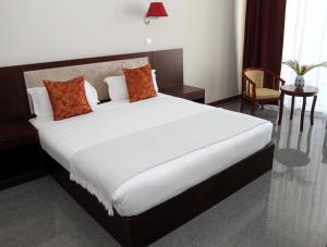 a bedroom with a large white bed with red pillows at Flow Hotel Benguela in Benguela