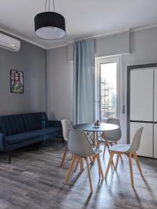 a living room with a table and chairs and a couch at Bardolino Center Apartments in Bardolino