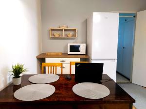 a kitchen with a wooden table and a microwave at Arantilan rivitalokaksio in Nakkila