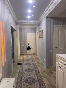 a hallway with a rug on the floor and a door at Квартира in Pavlodar