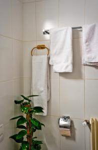 een badkamer met witte handdoeken en een plant erin bij Studio 5 places à deux pas du Lac in Territet