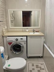 a bathroom with a washing machine and a sink at Квартира in Pavlodar