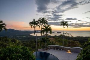a villa with a swimming pool and palm trees at Beautiful House with Sweeping Ocean Views, Modern Design, and a Private Infinity Pool in Potrero