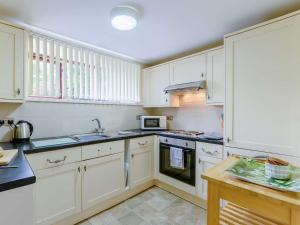 a kitchen with white cabinets and a microwave at 2 Bed in Keswick 28383 in Braithwaite