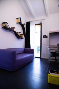 ein Wohnzimmer mit einem lila Sofa und einem Tisch in der Unterkunft Bologna Rooftop - Affitti Brevi Italia in Bologna
