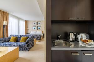 a kitchen and a living room with a couch at Jade Manotel in Geneva