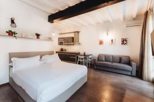 a bedroom with a large white bed and a kitchen at Charming Milan Apartments Brera - Madonnina in Milan