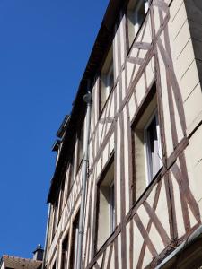 un edificio antiguo con ventanas contra un cielo azul en Appart Rouen Centre, en Rouen