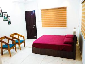Aamees paradise في Kolitottattuturu: غرفة نوم بسرير وطاولة وكرسي