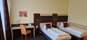 una camera d'albergo con 2 letti e una scrivania di Best Western Hotel Augusta a Augusta (Augsburg)