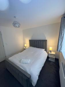 a bedroom with a large white bed with two lamps at Serenity Space Luxury Home 3 Bed House Near Bluewater in Kent