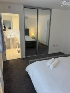 a bedroom with a white bed and a large mirror at Serenity Space Luxury Home 3 Bed House Near Bluewater in Kent
