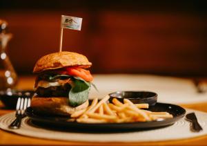 a sandwich and french fries on a plate at Hotel Chalé Capitólio in Capitólio