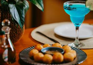 a plate of food on a table with a blue drink at Hotel Chalé Capitólio in Capitólio