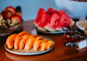 two plates of food on a table with fruit at Hotel Chalé Capitólio in Capitólio