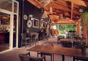 een restaurant met houten muren en tafels en stoelen bij Hotel De Werelt Garderen in Garderen