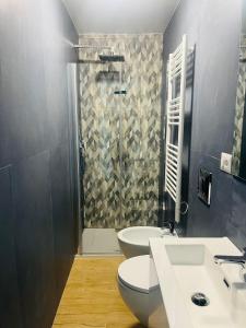 a bathroom with a shower and a toilet and a sink at Lomat Apartment in Milan