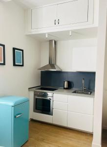 a kitchen with white cabinets and a stove and a sink at Lomat Apartment in Milan