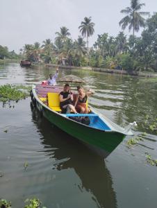 a group of people sitting in a boat on the water at The Lake Paradise Boutique Resort in Alleppey