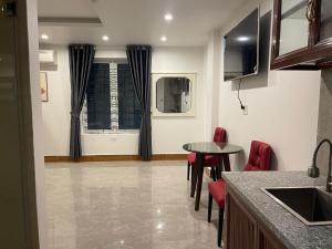 a kitchen with a table and chairs and a window at IVY Homestay in Hai Phong