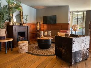 a living room with a fireplace and a tv at Hotel De Werelt Garderen in Garderen