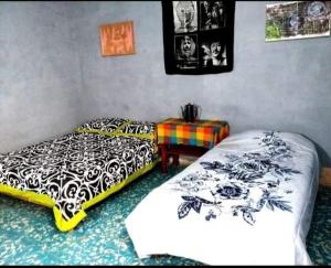 a bedroom with two beds and a table in it at Posada Hortencia in Aguascalientes