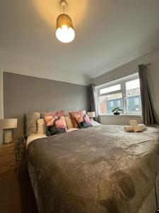 a bedroom with a large bed and a window at A Very Spacious House-4BR-Sleeps 8 in Warrington