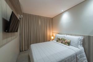 a small bedroom with a bed and a television at Pousada Tartarugas Marinhas in Fernando de Noronha