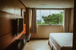 una camera d'albergo con letto e finestra di Barrudada Santarém a Santarém