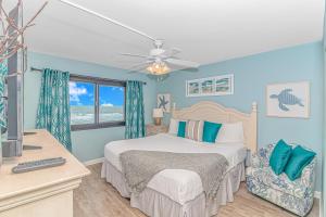 Un dormitorio con una cama con paredes azules y una ventana en Beautifully Updated 2 Bedroom Oceanfront Suite- With Gaming System and More! Horizon East 104, en Myrtle Beach